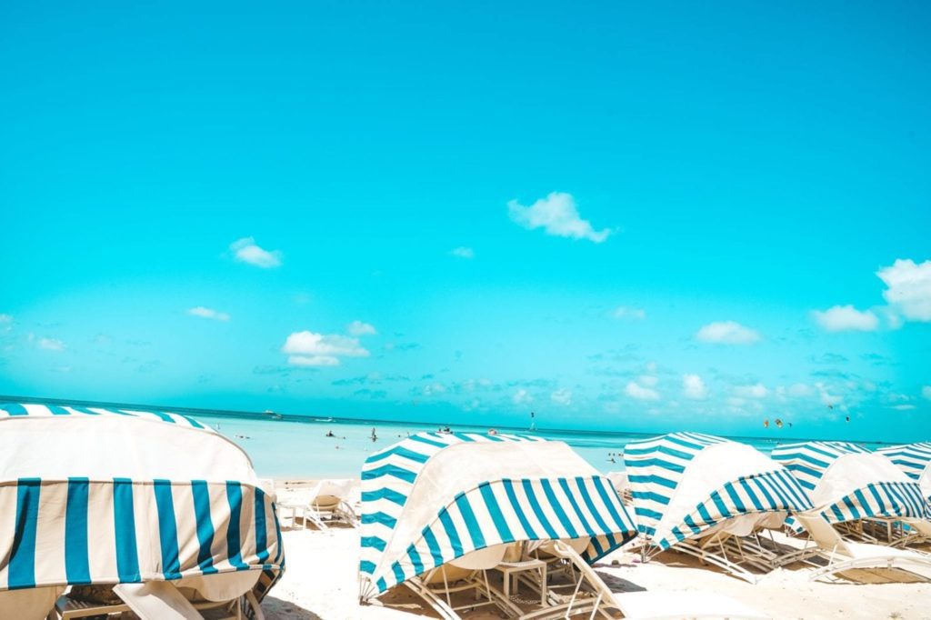Striped beach umbrellas on the white sand in Aruba