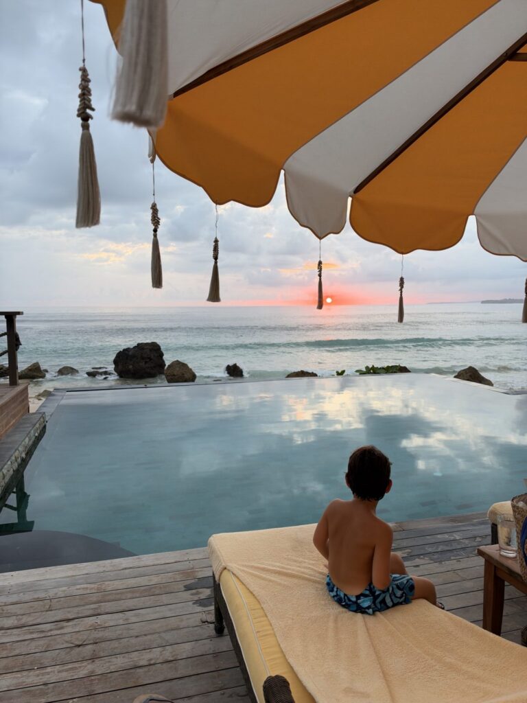 Toddler on a lounger overlooking the infinity pool and ocean at NIHI Sumba
